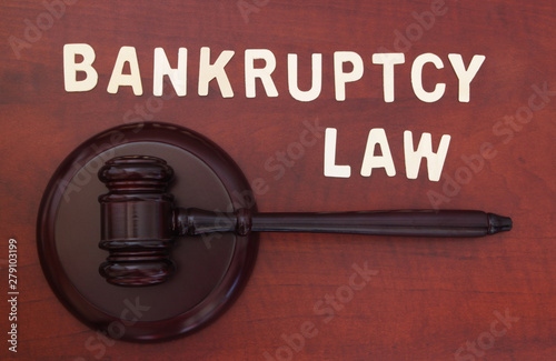 Bankruptcy concept with judge gavel and word bankruptcy on wooden table photo