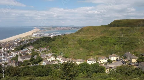 Pan to Chesil Beach and Portland Harbour which links Weymouth with Portland in Dorset England. The small town of Fortuneswell is in the foreground. photo