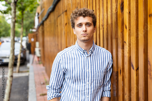 smart men standing against a wooden wall photo