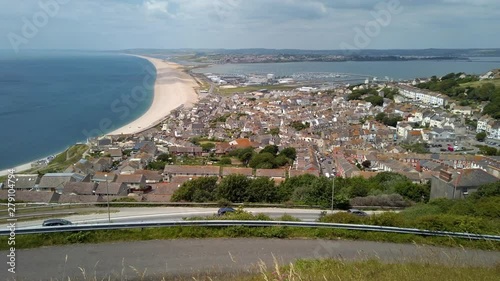 Pan to Chesil Beach and Portland Harbour which links Weymouth with Portland in Dorset England. The small town of Fortuneswell is in the foreground. photo