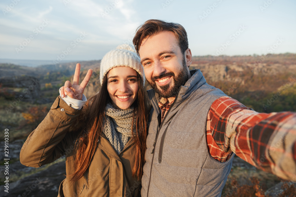 Loving couple outside in free alternative vacation camping over mountains take selfie by camera.