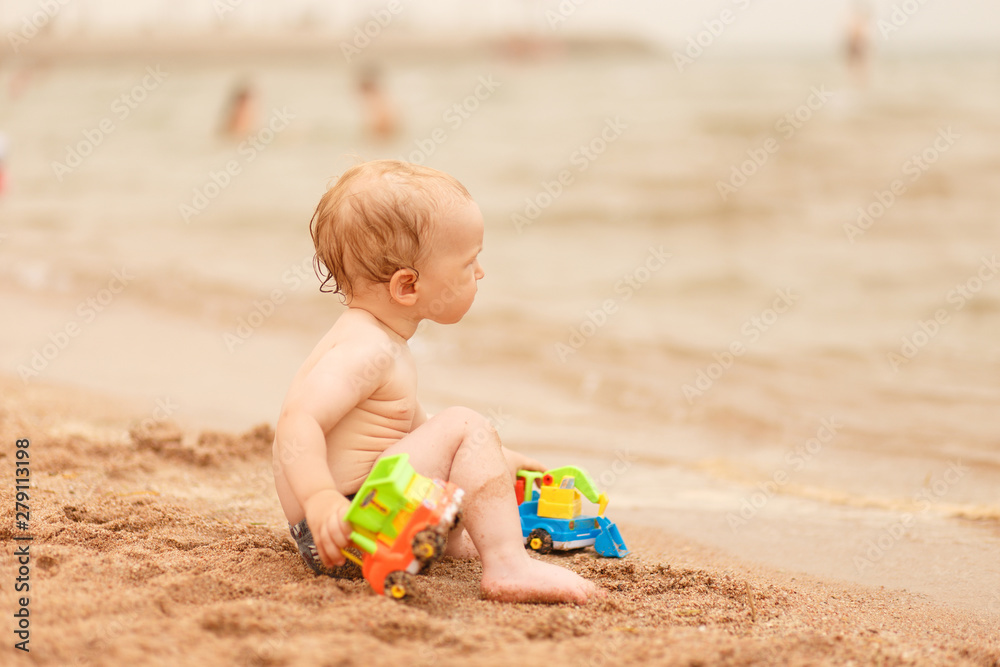 Little kid playing with sand on sea beach. Little kid playing with sand on sea beach.