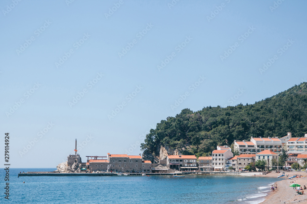 Beautiful view of the coastal resort town of Petrovac in Montenegro with the old fort and buildings and the beach.
