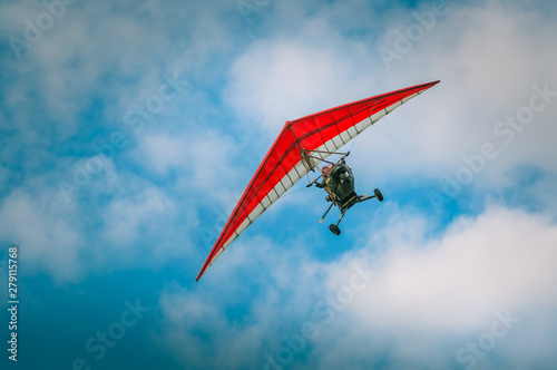 Ultralight aircraft flight in the blue air with clowds photo