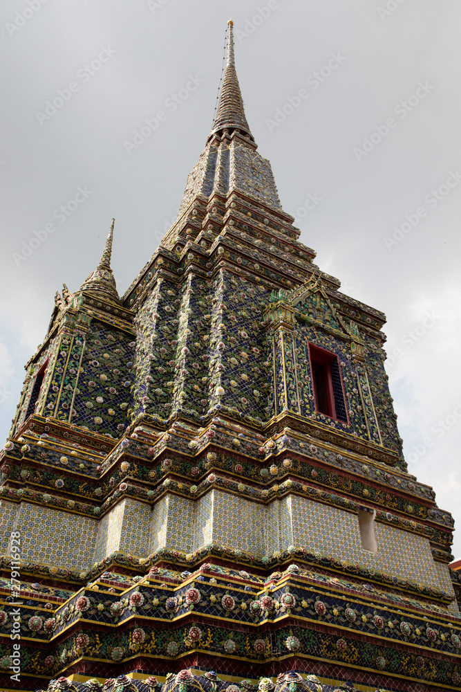 Fototapeta premium Side view of the pagodas of a temple in Bangkok with cloudy sky as background