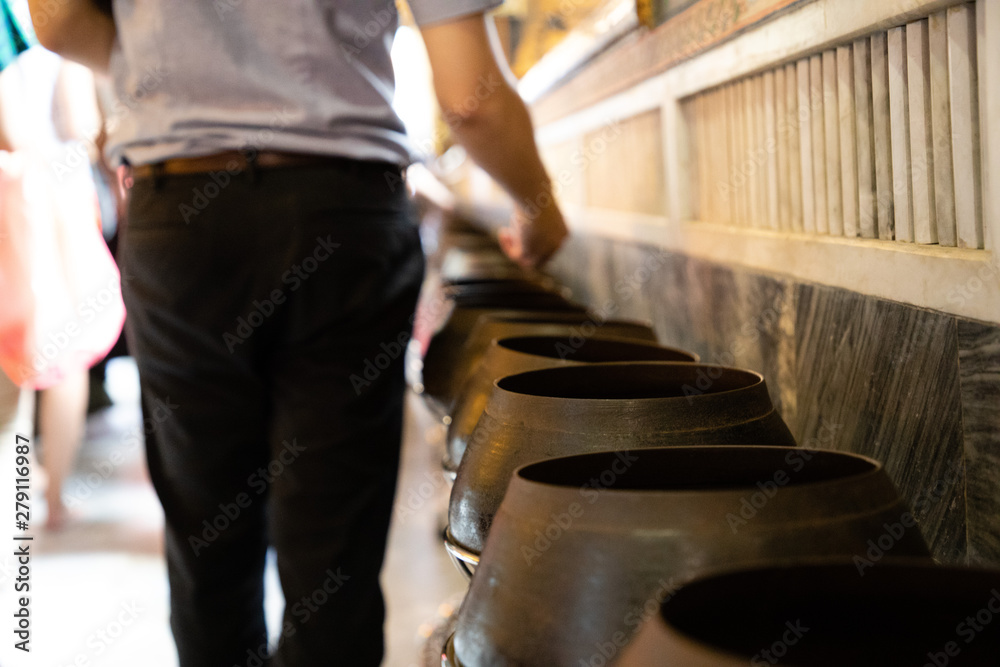 Man donating coins in thai temple for luck and prosperity Man donating coins in thai temple for luck and prosperity