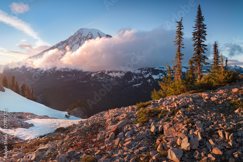 Mount Rainier towers over the surrounding mountains sitting at an elevation of 14,411 ft. It is considered to be one of the world's most dangerous volcanoes. Spring time, sunny day. Washington, USA