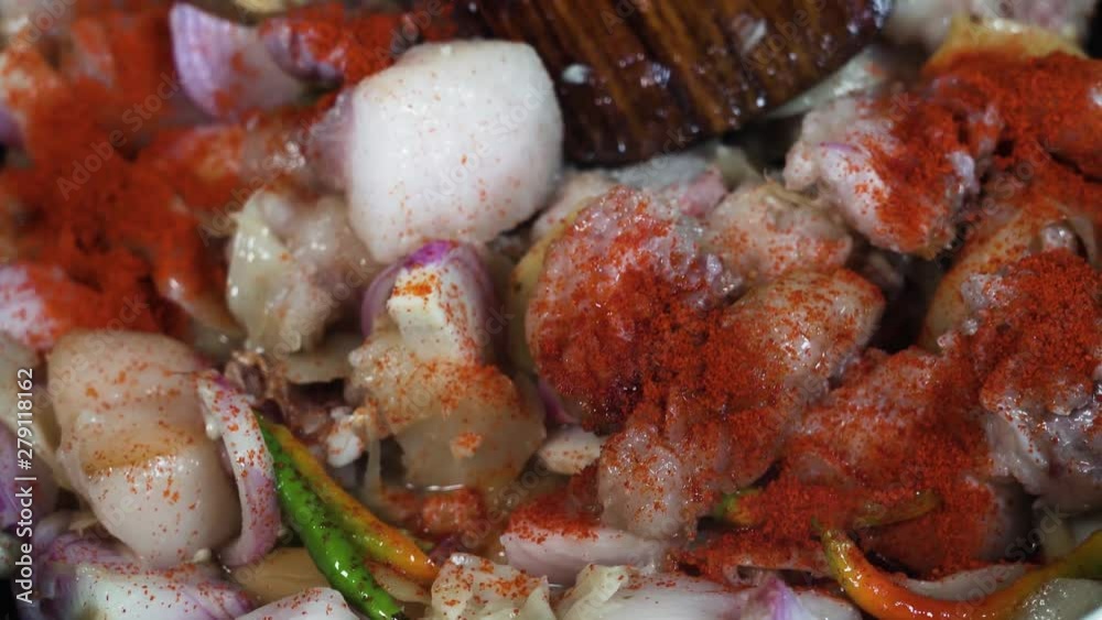 Seasoning the pork and vegetables frying in a pan with ground paprika Seasoning the pork and vegetables frying in a pan with ground paprika