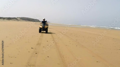 Shot Three. Tracking Action Shot of Quad Bikes on Deserted Beach in Morocco. photo