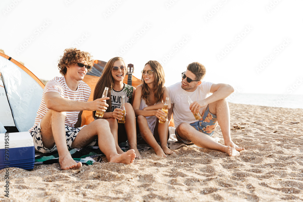 Group of cheerful happy friends camping at the beach Group of cheerful happy friends camping at the beach