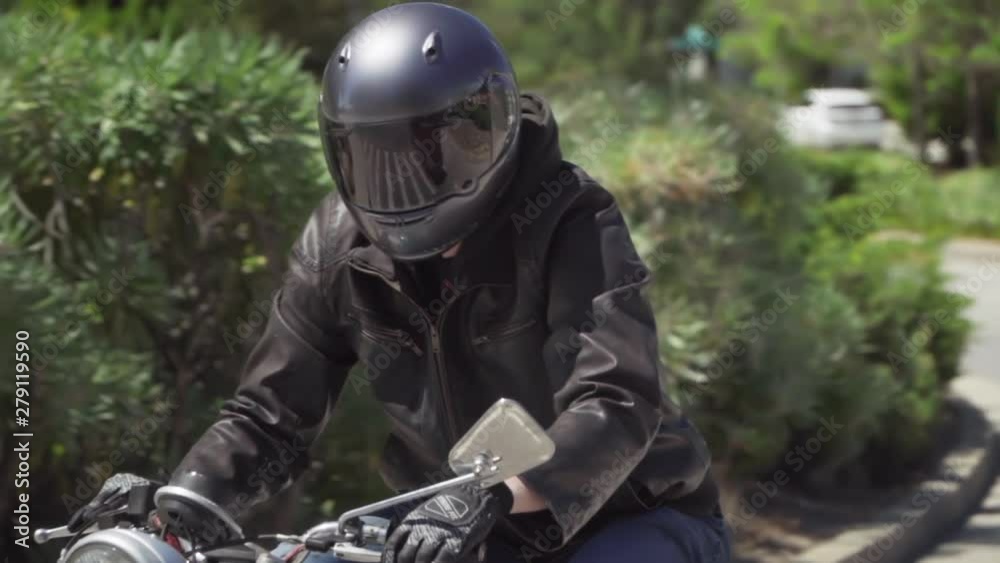 Slow Motion of Motorcyclist With Leather Jacket Starting on a Turn From a Stop Slow Motion of Motorcyclist With Leather Jacket Starting on a Turn From a Stop