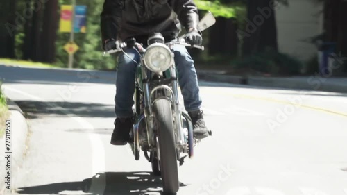 Motorcyclist With Leather Jacket Riding on a Wooded Road photo