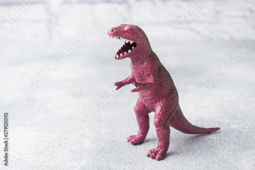 Dinosaur on a gray background. Plastic rubber toy. Selective focus. photo