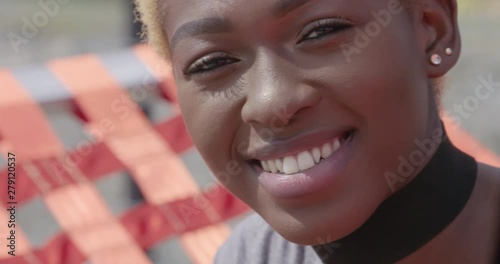 Close up portrait of a stylish, attractive woman smiling in the sunlight photo