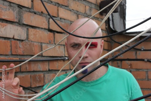 portrait of a painted man on the background of a brick wall of wire © Ксения Куприянова