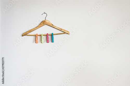 hanger with colorful clothespins on white wall