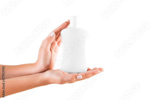 Female hand holding cream bottle of lotion isolated. Girl give cosmetic products on white background