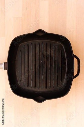 Fat-less pan on wooden background, top view