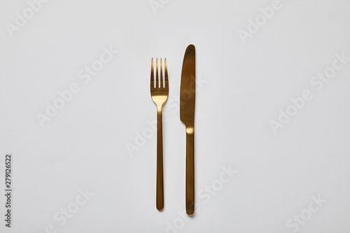 top view of golden fork and knife isolated on white