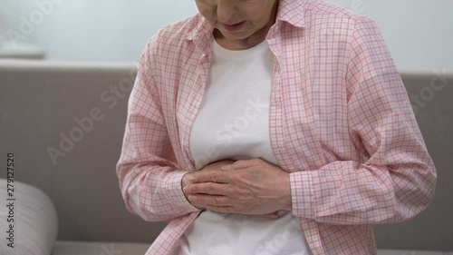 Senior woman holding stomach, suffering from gastritis problems, health care
