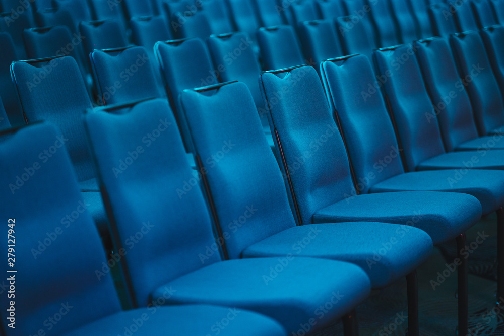 Blue empty seats in the audience prepared for the participants of the conference or presentation. Blue empty seats in the audience prepared for the participants of the conference or presentation.