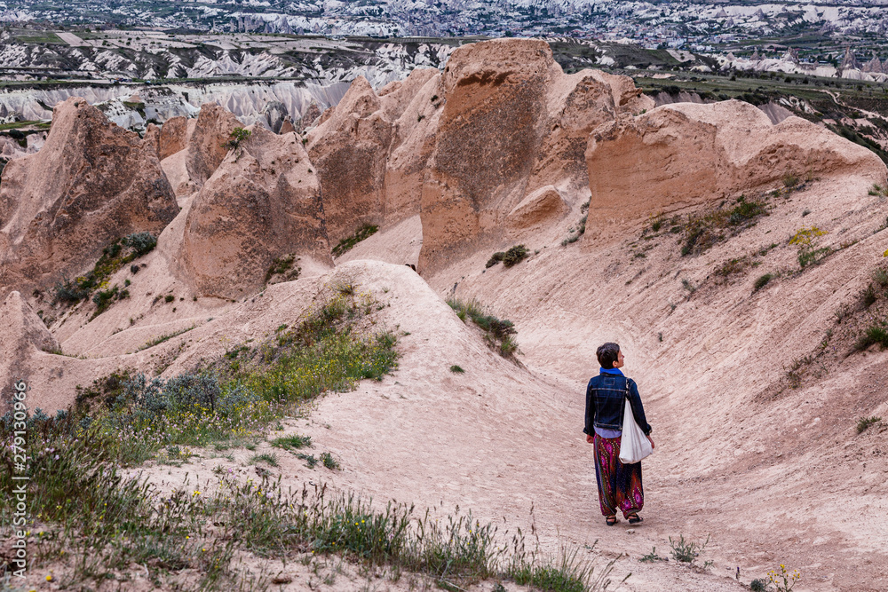 Woman tourist in the Rose valley of Cappadocia. Walk in the sandy mountains.