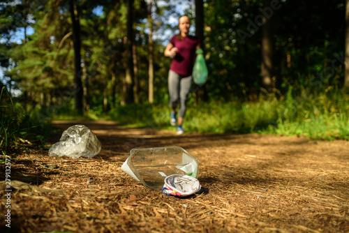 Woman jogging with garbage bag photo