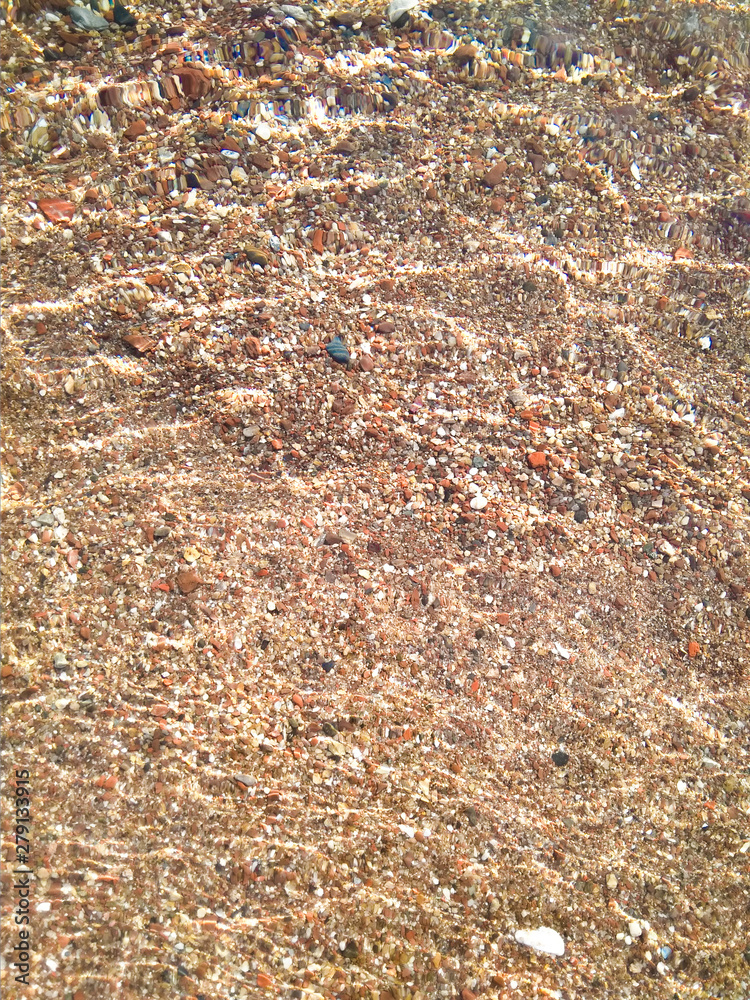 pebbles through the shallow clear water pebbles through the shallow clear water