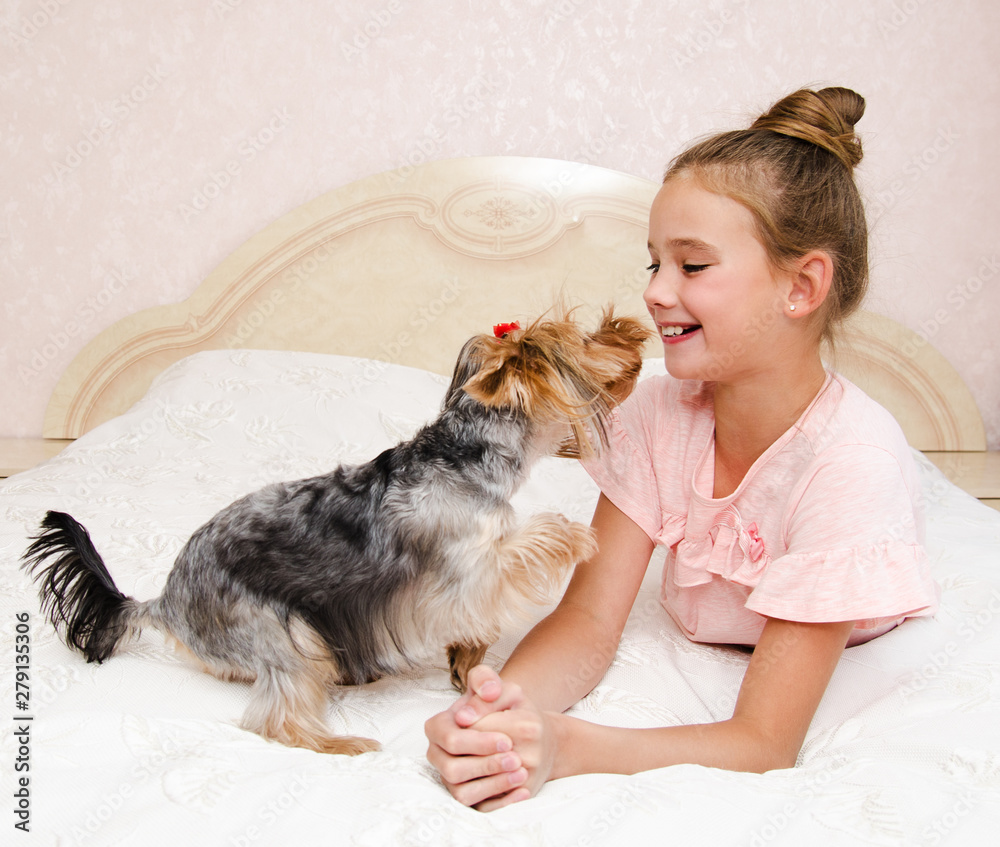 Adorable smiling happy little girl child playing with puppy yorkshire terrier Adorable smiling happy little girl child playing with puppy yorkshire terrier