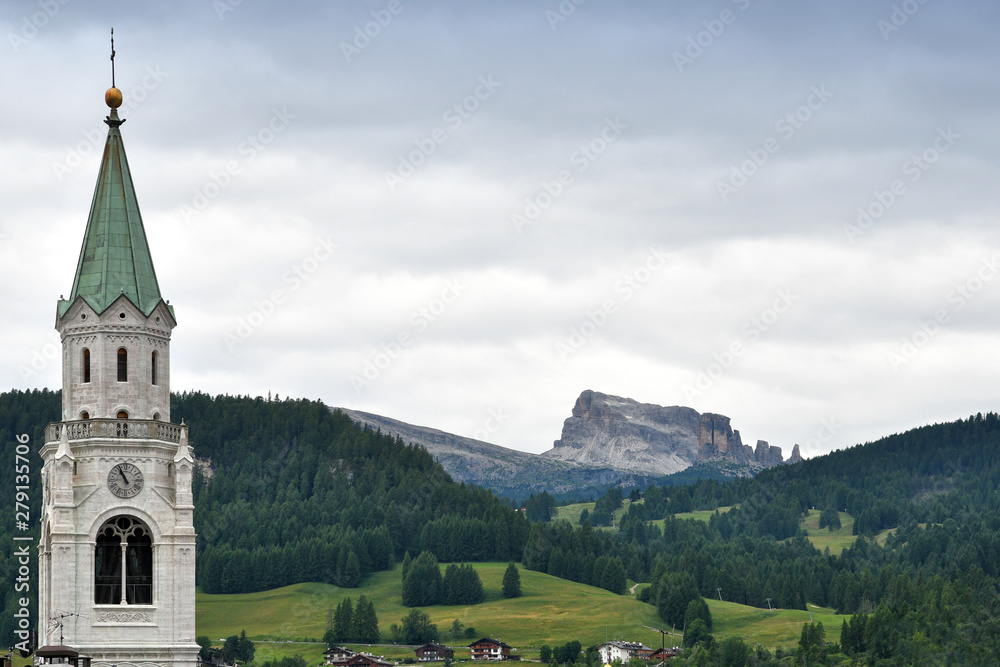 The Church of Cortina d'Ampezzo with Cinque Torri Dolomitic group on the background (Sexten Dolomites). Veneto Italy, Europe.