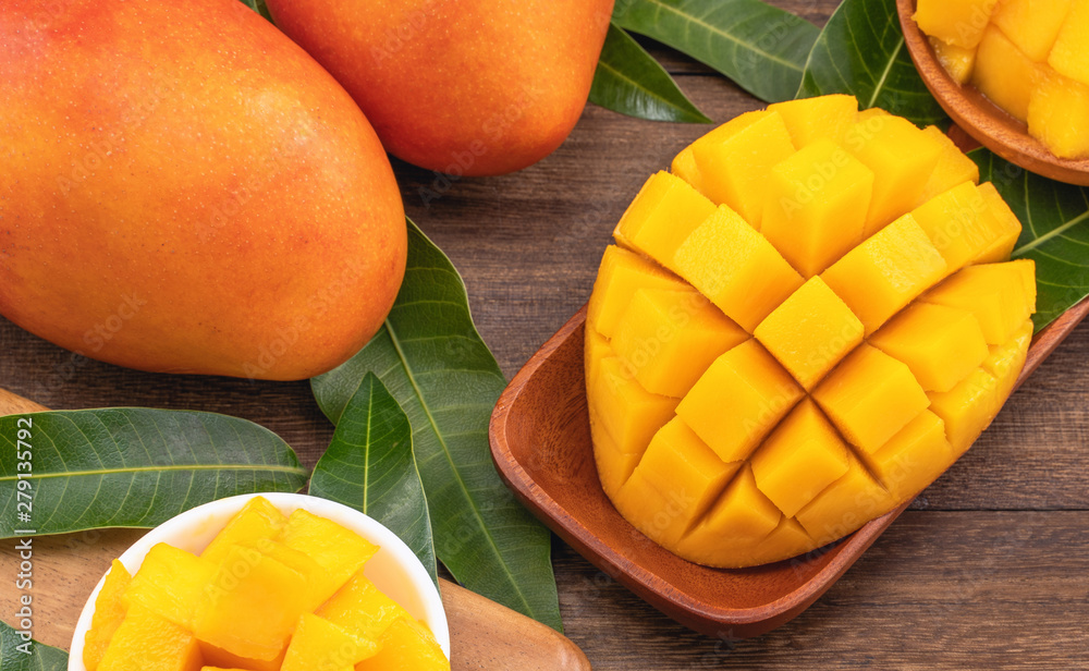Fresh chopped mango cubes on wooden cutting board and rustic timber background. Tropical summer fruit concept, close up, macro, copy space. Fresh chopped mango cubes on wooden cutting board and rustic timber background. Tropical summer fruit concept, close up, macro, copy space.
