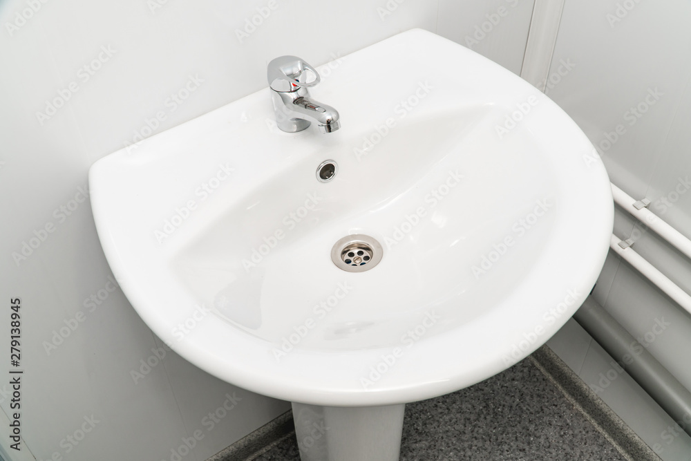 White clean sink with the crane in the bathroom White clean sink with the crane in the bathroom