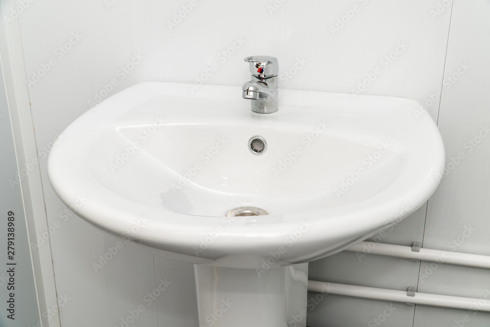 White clean sink with the crane in the bathroom White clean sink with the crane in the bathroom