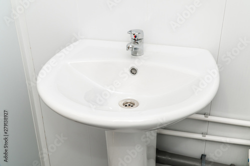 White clean sink with the crane in the bathroom