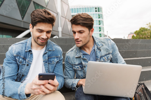 Two smiling young men friends dressed casually