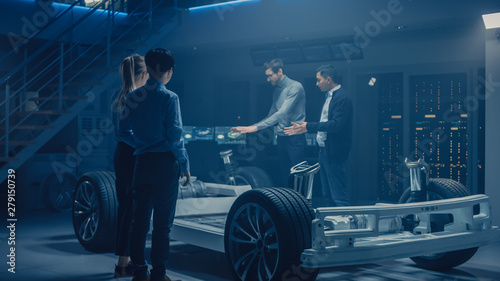 Team of Automobile Design Engineers in Automotive Innovation Facility Working on Electric Car Platform Chassis Prototype that Includes Wheels, Suspension, Hybrid Engine and Battery © Gorodenkoff