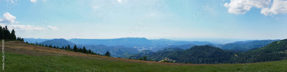 Panoramic view of the mountains under the blue cloudy sky in summer