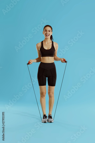 Sport woman with fit body in sportswear and skipping rope