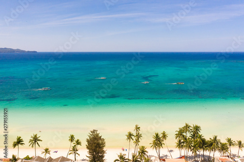 Tropical beach with white sand and palm trees, view from above. Turquoise lagoon with a sandy bottom. Beach of the island of Boracay, Philippines.