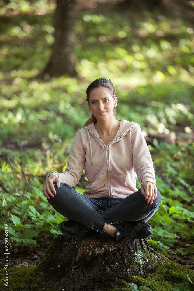 Beautiful woman meditating in the forest on a sunny morning Beautiful woman meditating in the forest on a sunny morning