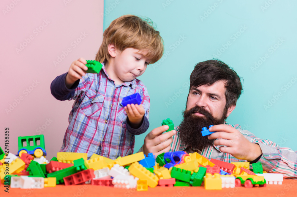 Naklejka premium Enjoying time in play club. love. child development. father and son play game. happy family leisure. small boy with dad playing together. building with colorful constructor. I am busy