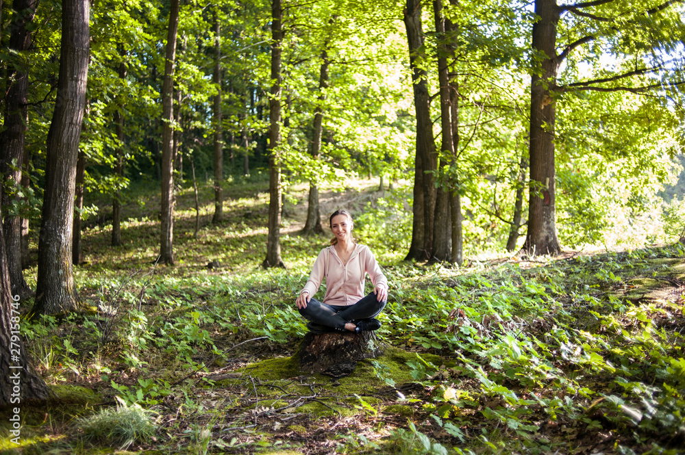 Beautiful woman meditating in the forest on a sunny morning Beautiful woman meditating in the forest on a sunny morning