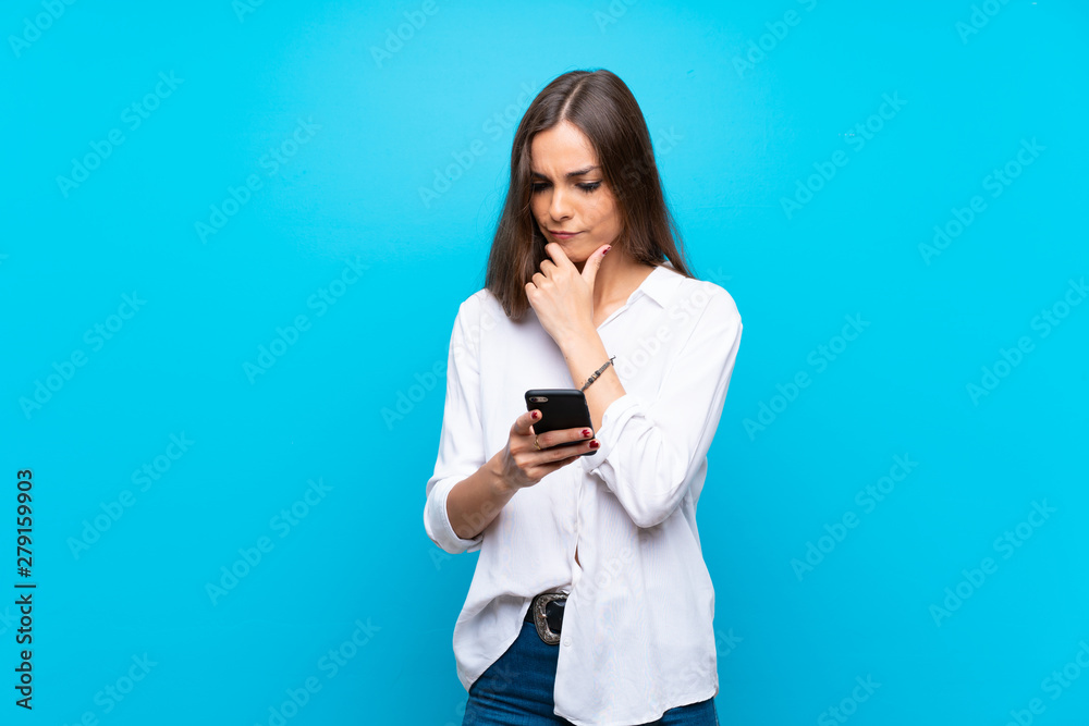 Young woman over isolated blue background thinking and sending a message Young woman over isolated blue background thinking and sending a message