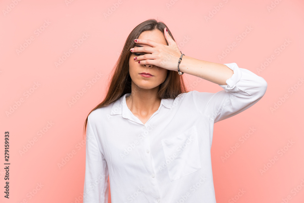 Young woman over isolated pink background covering eyes by hands Young woman over isolated pink background covering eyes by hands