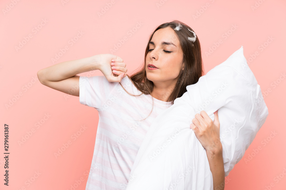 Young woman in pajamas over isolated pink background yawning Young woman in pajamas over isolated pink background yawning