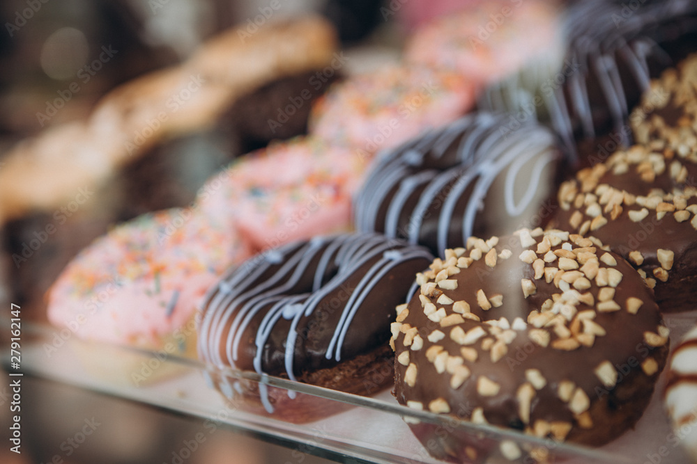 assorted donuts with chocolate frosted, pink glazed and sprinkles donuts which are located on the refrigerator showers so that buyers can choose what they like assorted donuts with chocolate frosted, pink glazed and sprinkles donuts which are located on the refrigerator showers so that buyers can choose what they like