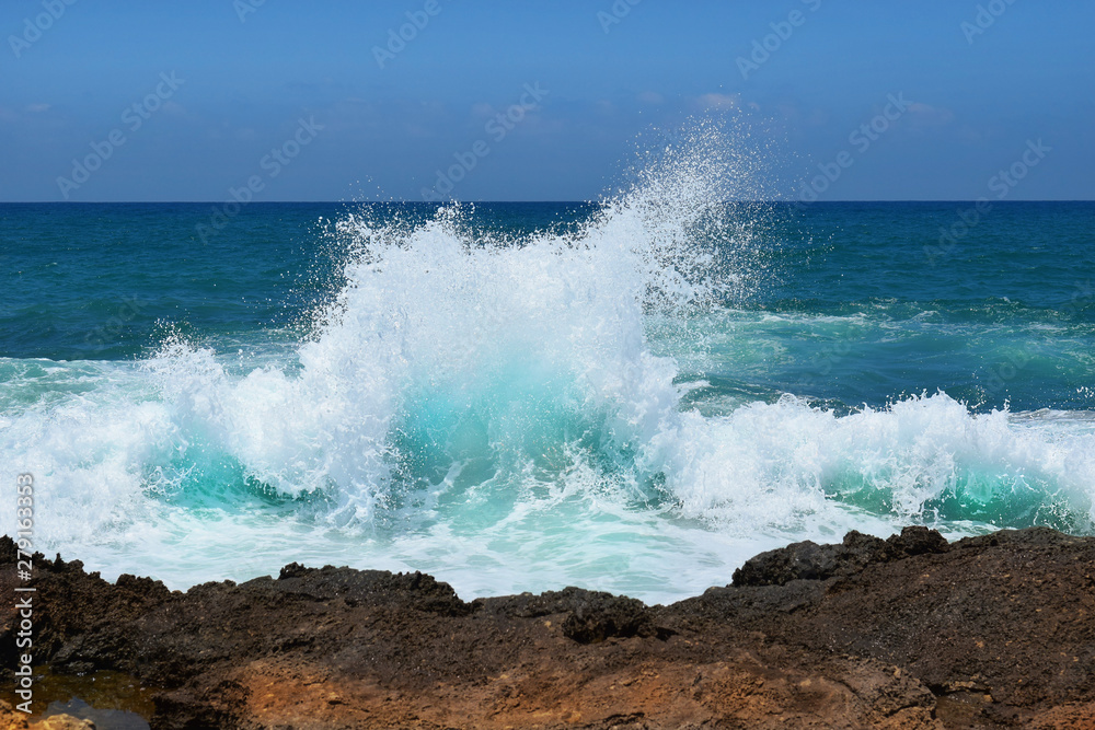sea wave crashing on rocks