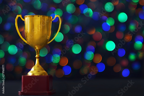 Winner hold trophy with abstract bokeh light background