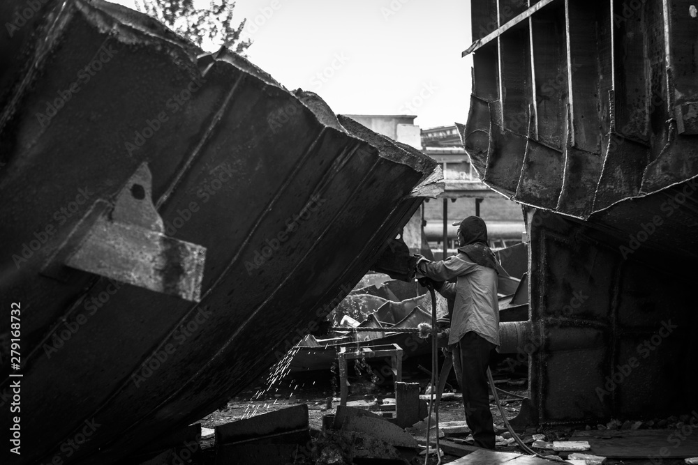 Zhuhai/China – April, 23rd 2017: Shipbreaking Yard in Zhuhai, worker dismantling with scrap metal, using gas to cut barge, ship Zhuhai/China – April, 23rd 2017: Shipbreaking Yard in Zhuhai, worker dismantling with scrap metal, using gas to cut barge, ship