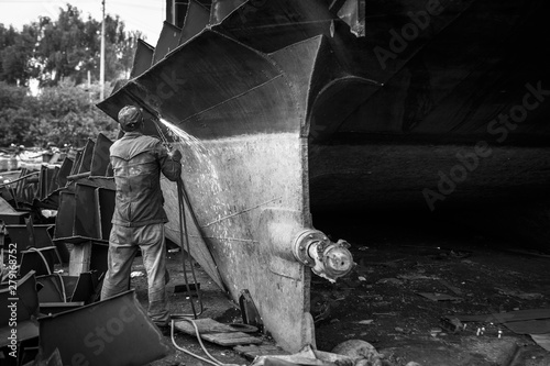 Zhuhai/China – April, 23rd 2017: Shipbreaking Yard in Zhuhai, worker dismantling with scrap metal, using gas to cut barge, ship photo